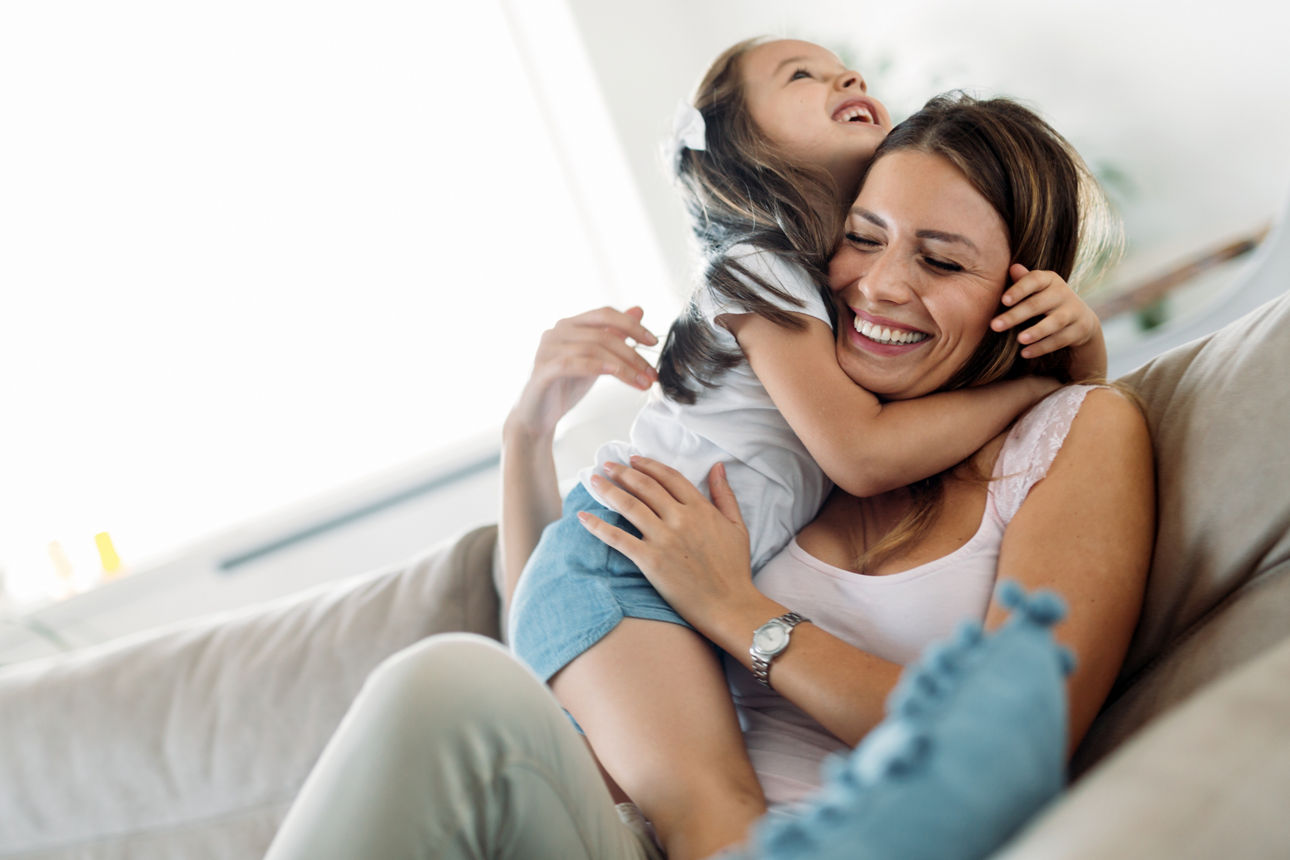 Mutter und Tochter albern auf dem Sofa herum