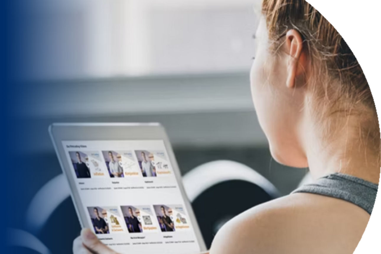 Eine junge Frau schaut auf ein Tablet mit fit4trading Videos