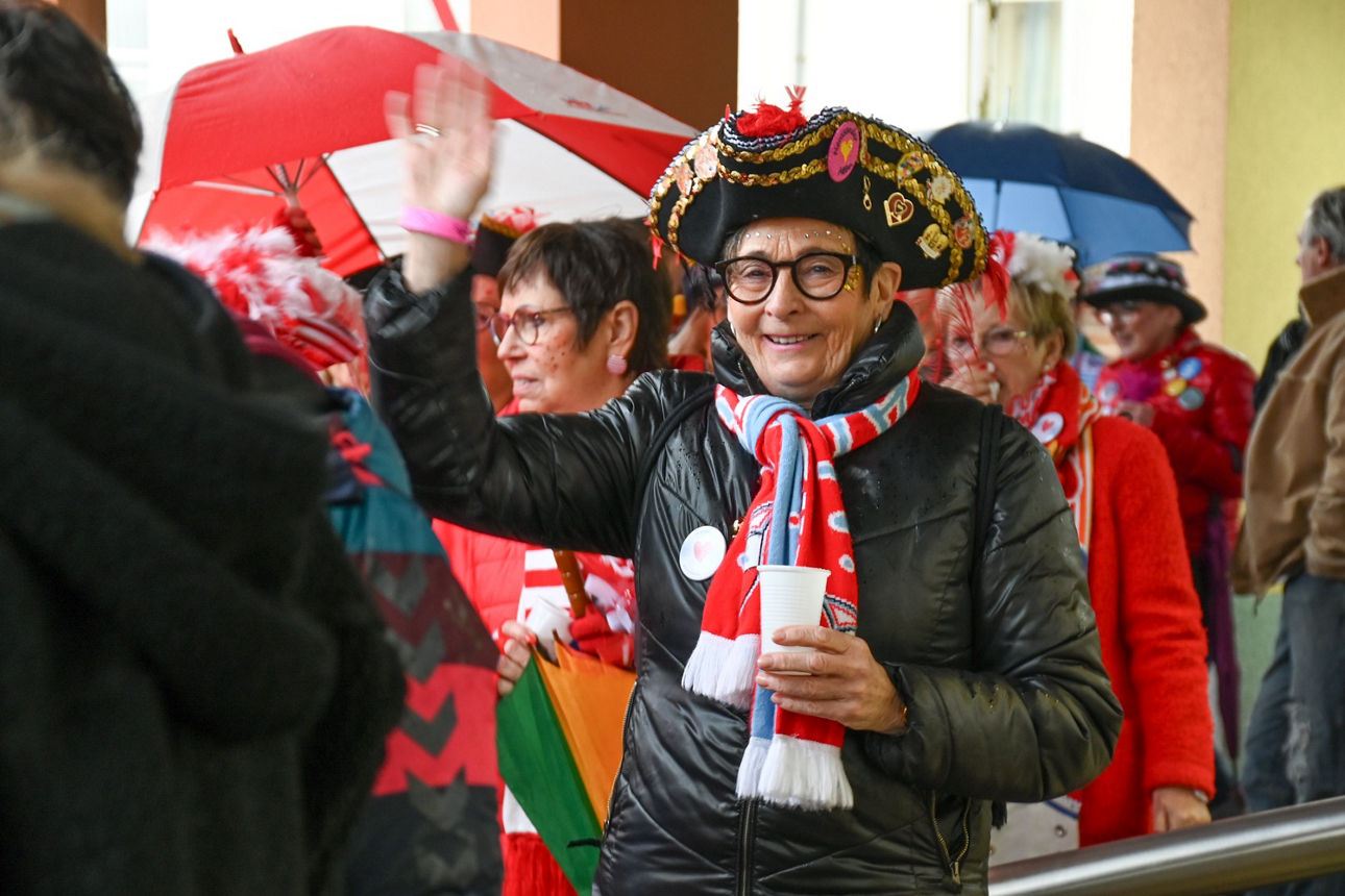 Christa Salz mit Dreispitz und Schal des NKV winkt in die Kamera