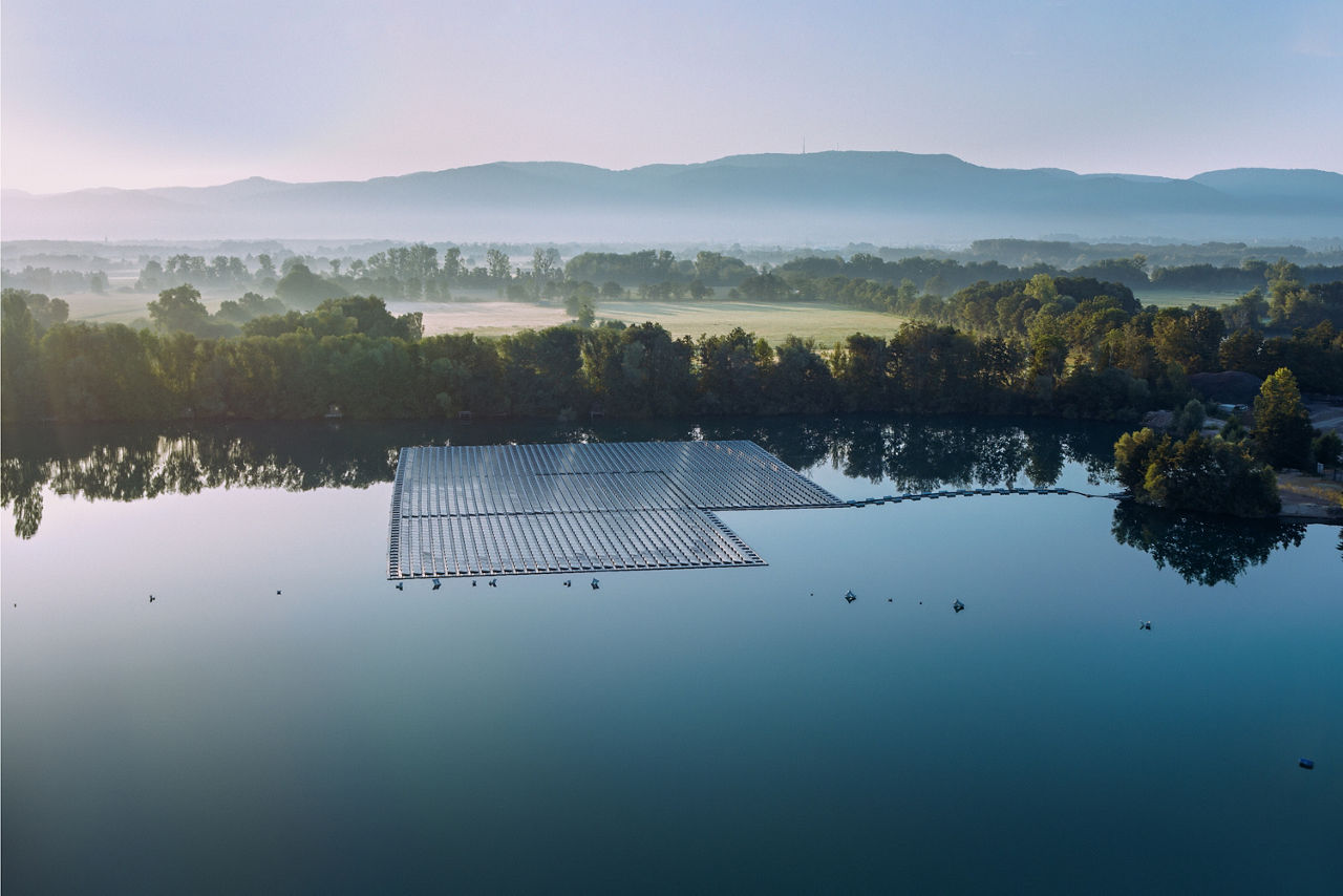 Eine Luftaufnahme eines großen Solarpanels, das auf einem ruhigen See schwimmt.