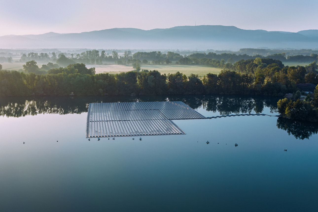 Eine Luftaufnahme eines großen Solarpanels, das auf einem ruhigen See schwimmt.