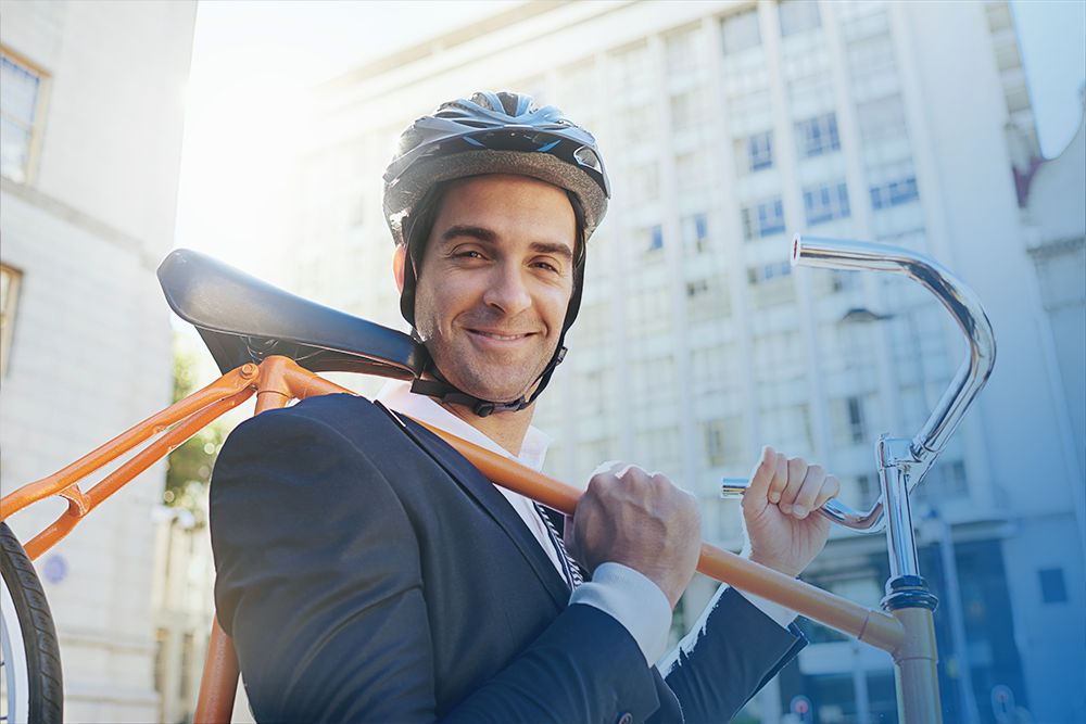 Junger Mann mit Fahrrad auf der Schulter, im Anzug