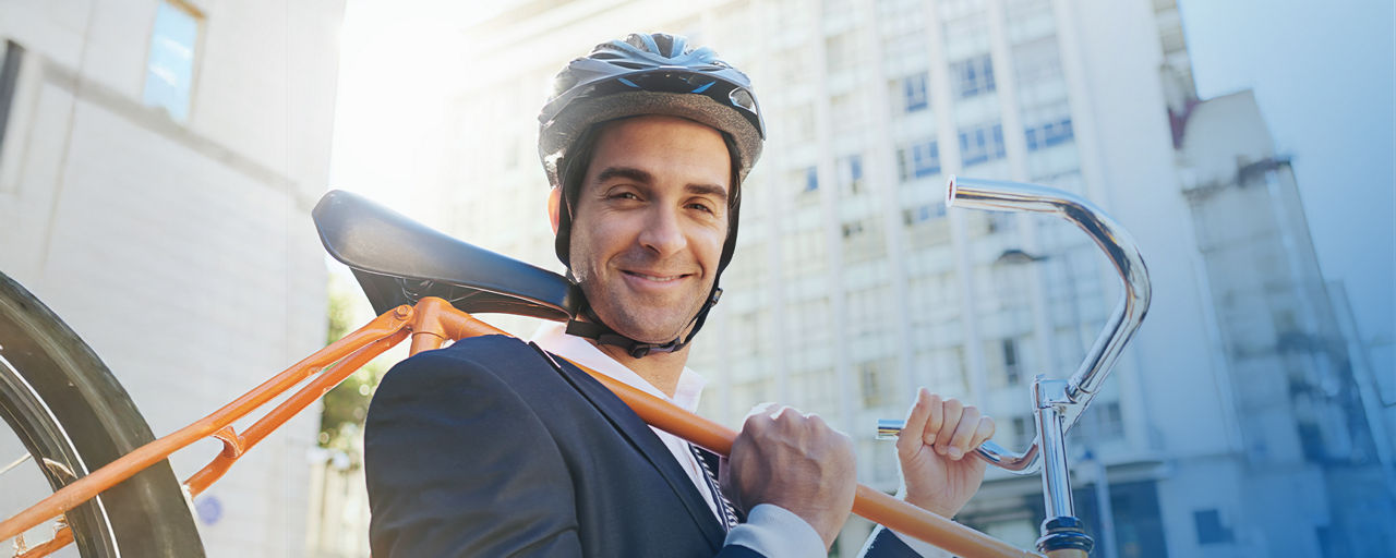 Mann mit Fahrrad über der Schulter in der Stadt