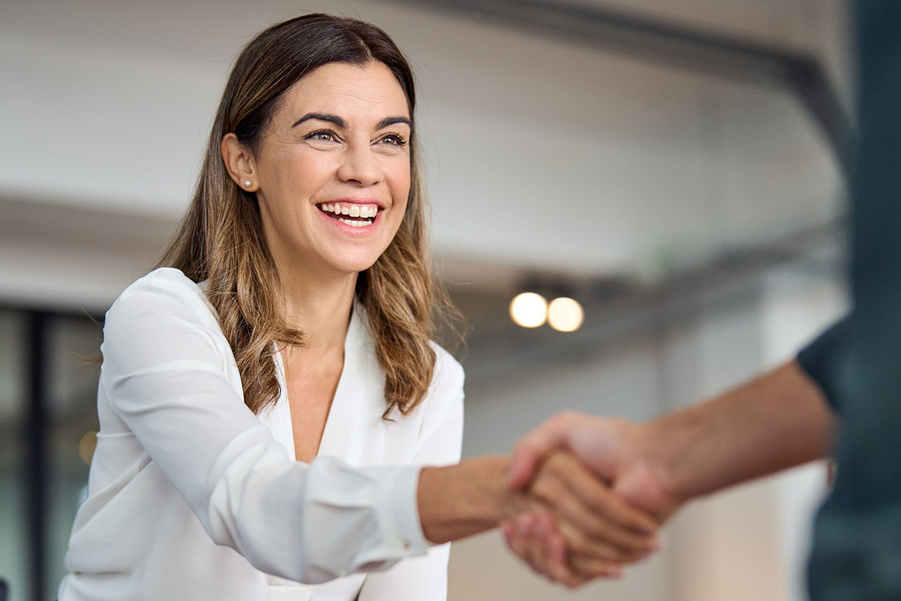 Frau schüttelt jemandem die Hand