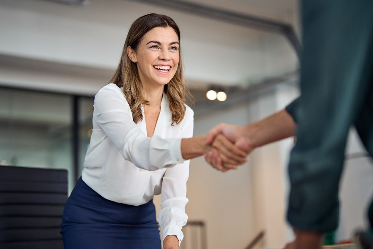 Frau schüttelt jemandem die Hand