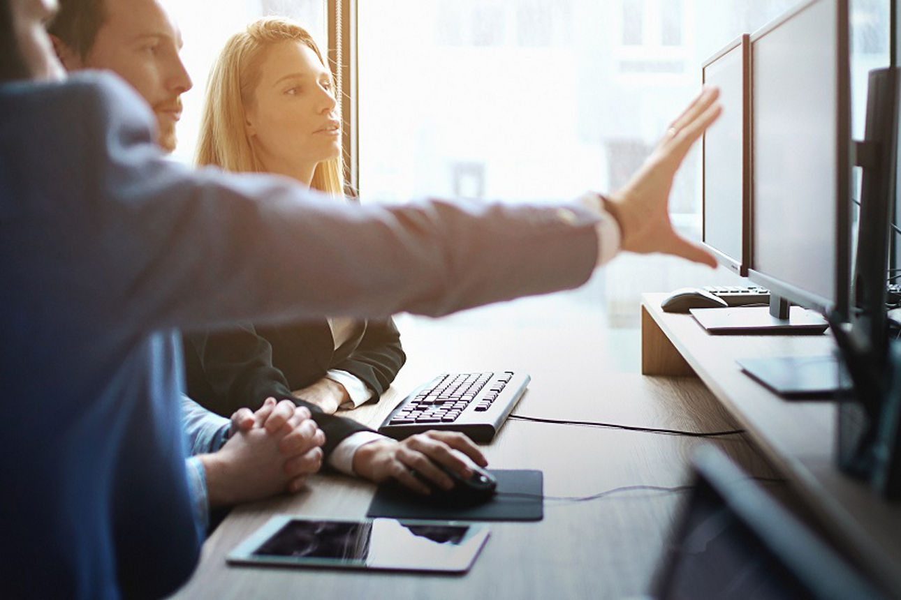 Drei Kollegen schauen auf einen Monitor