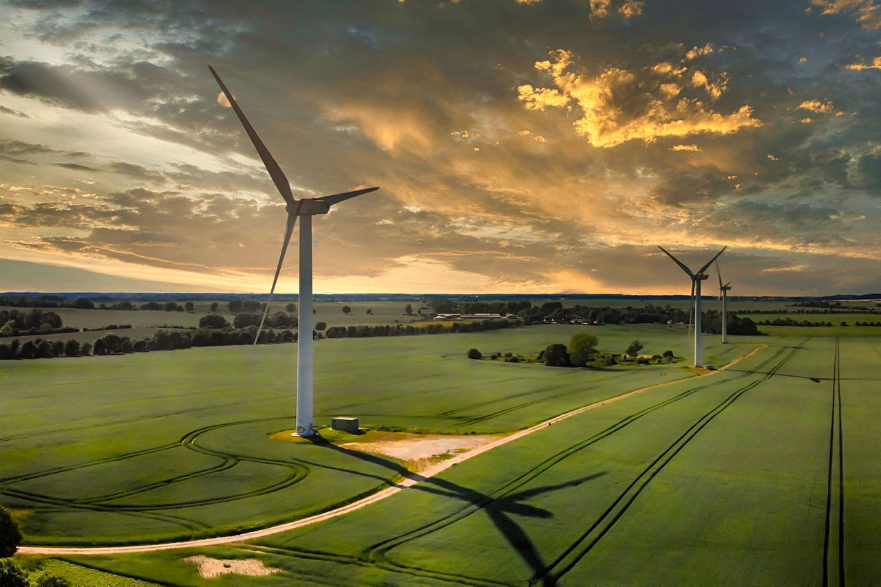 Landschaftsaufnahme mit Windkrafträdern in der Morgendämmerung