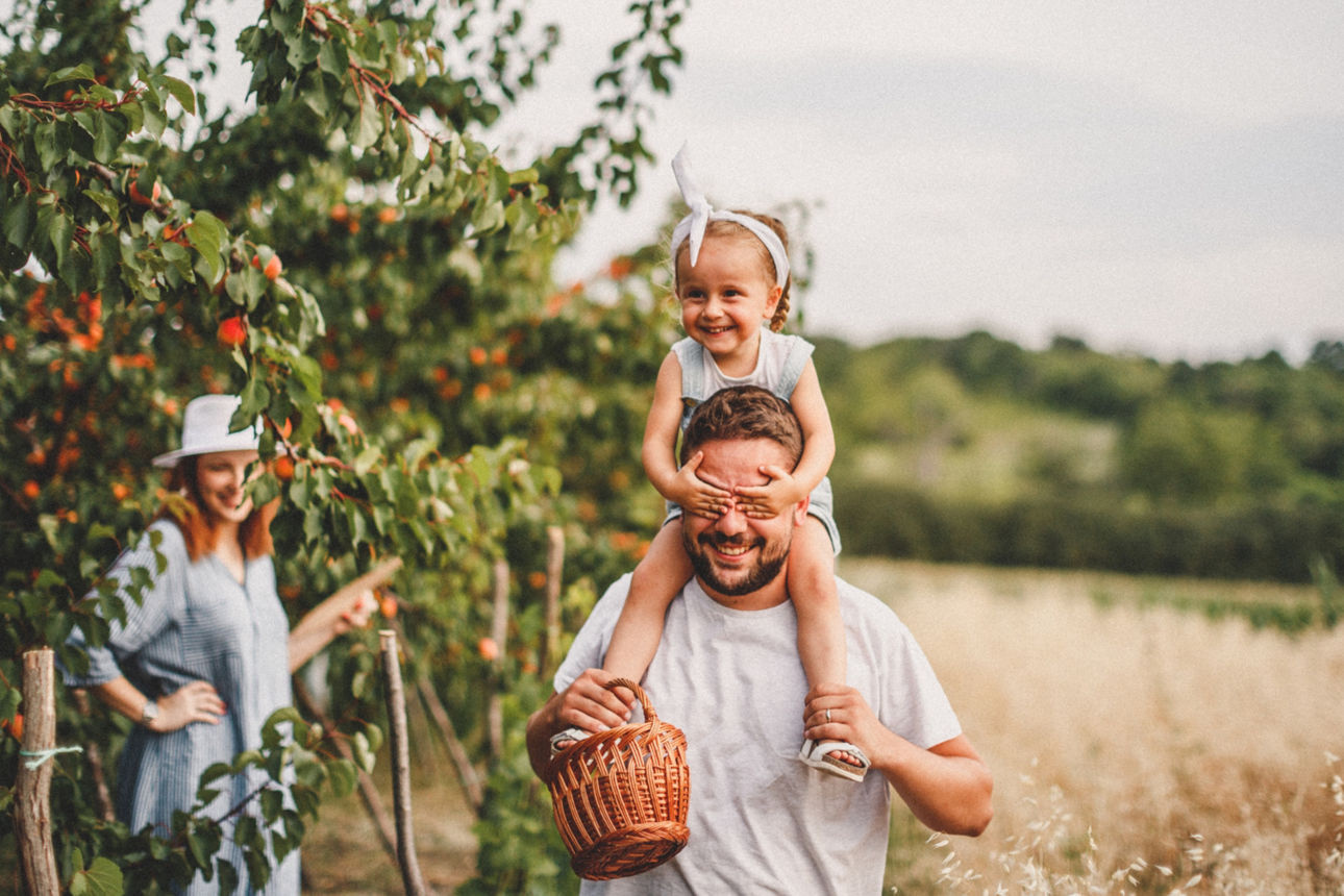 Mann trägt Kind auf den Schultern in der Natur