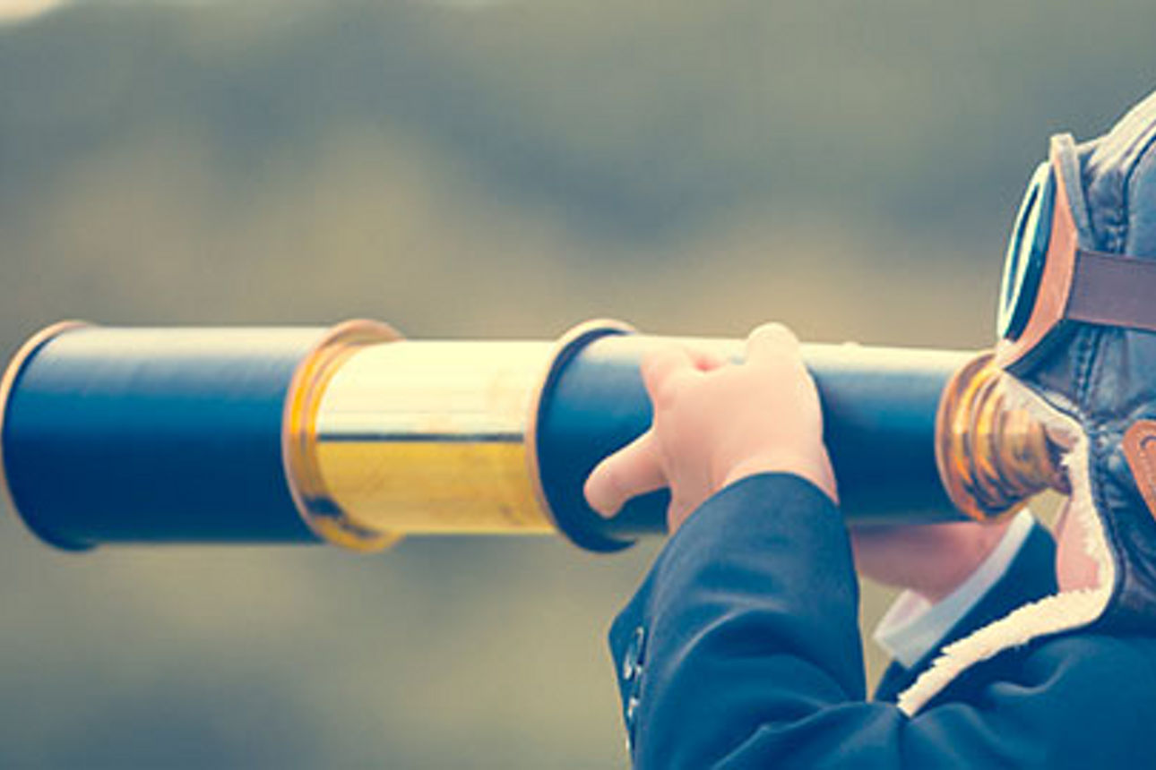 Ein Kind blickt durch ein Teleskop in die Ferne, den Blick auf einen fernen Horizont gerichtet.
