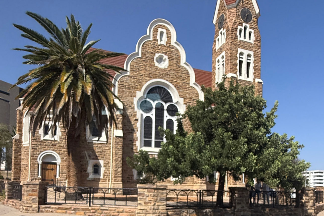 Kirche mit Palme und Eierbaum davor.