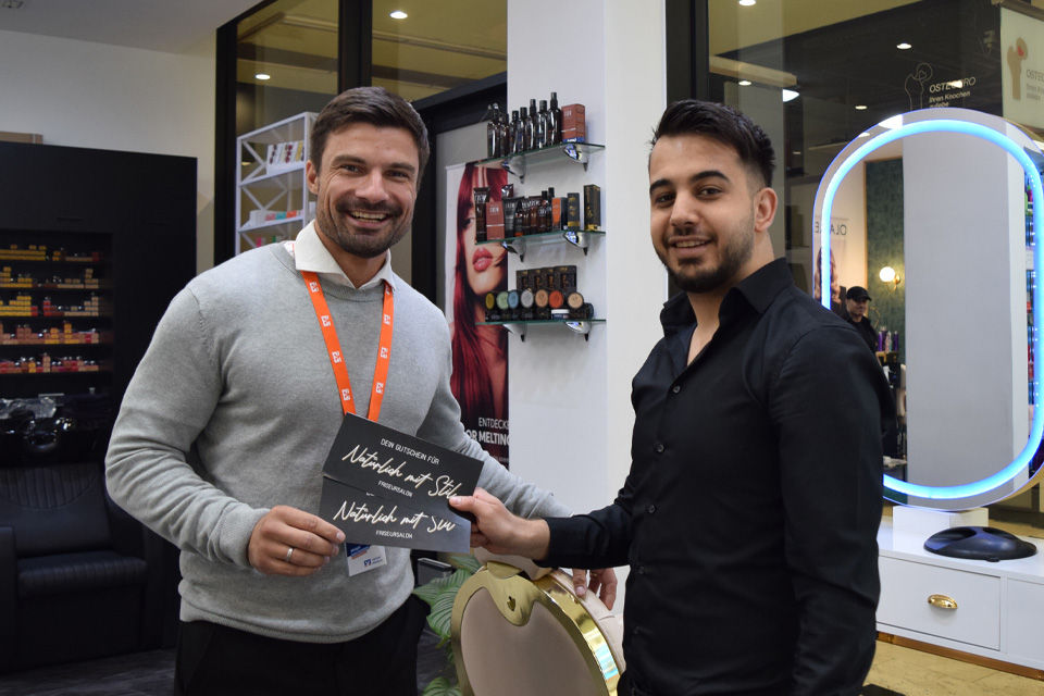 Sebastian Wähner und Abdelkareem Daoud bei der Gutscheinübergabe im Salon