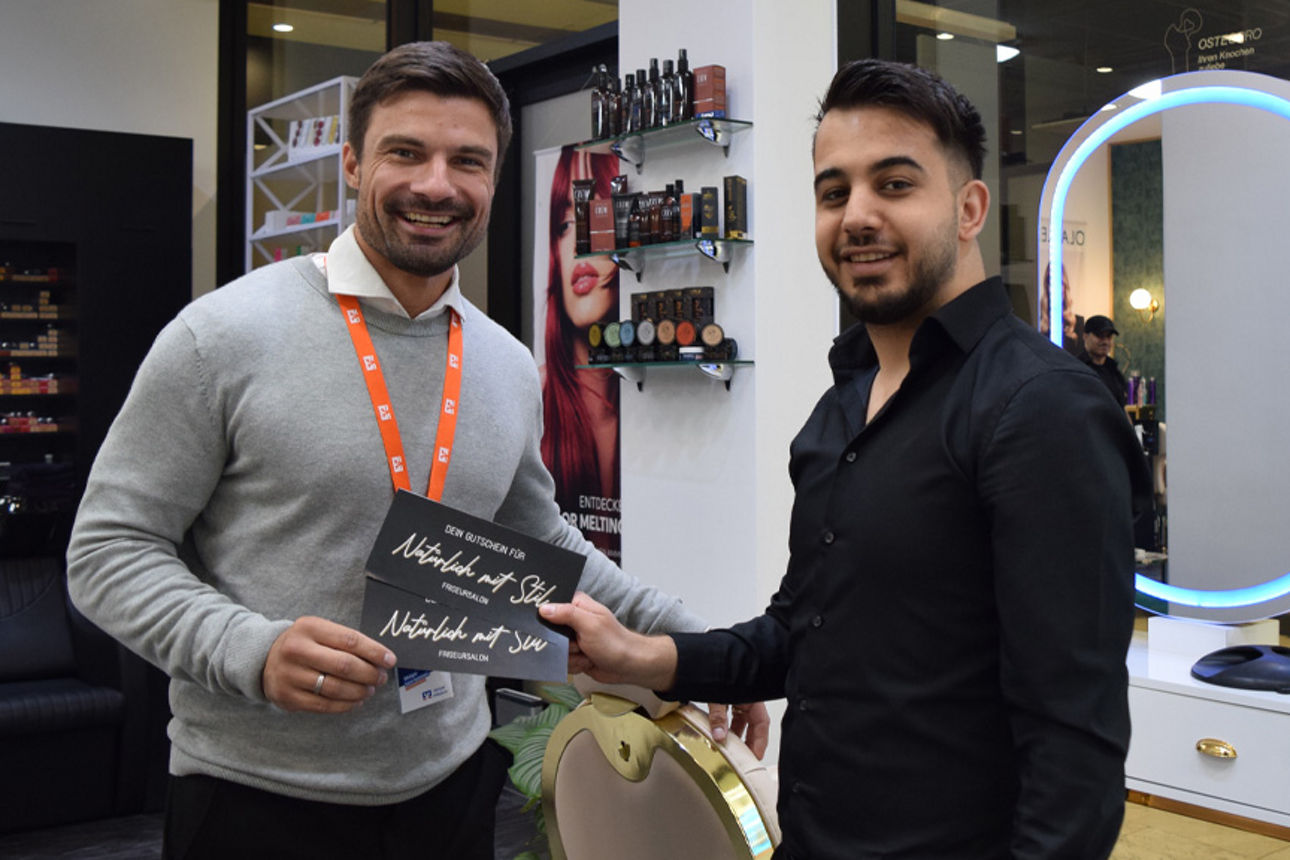 Sebastian Wähner und Abdelkareem Daoud bei der Gutscheinübergabe im Salon