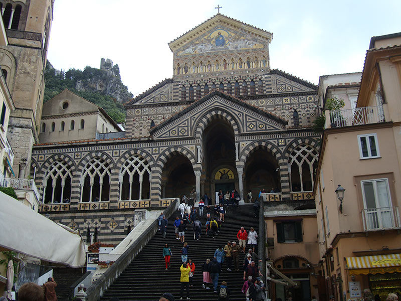 Eine große Kathedrale, geschmückt mit aufwendigen Mustern, steht majestätisch am oberen Ende einer steilen Treppe.