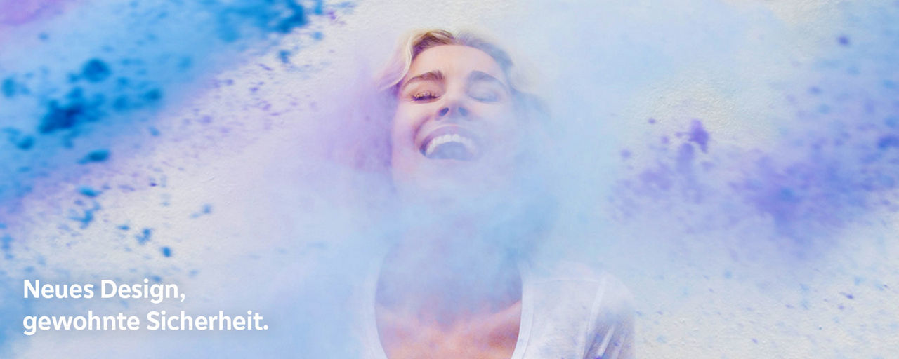 Eine junge Frau wird lachend mit Farbe beworfen