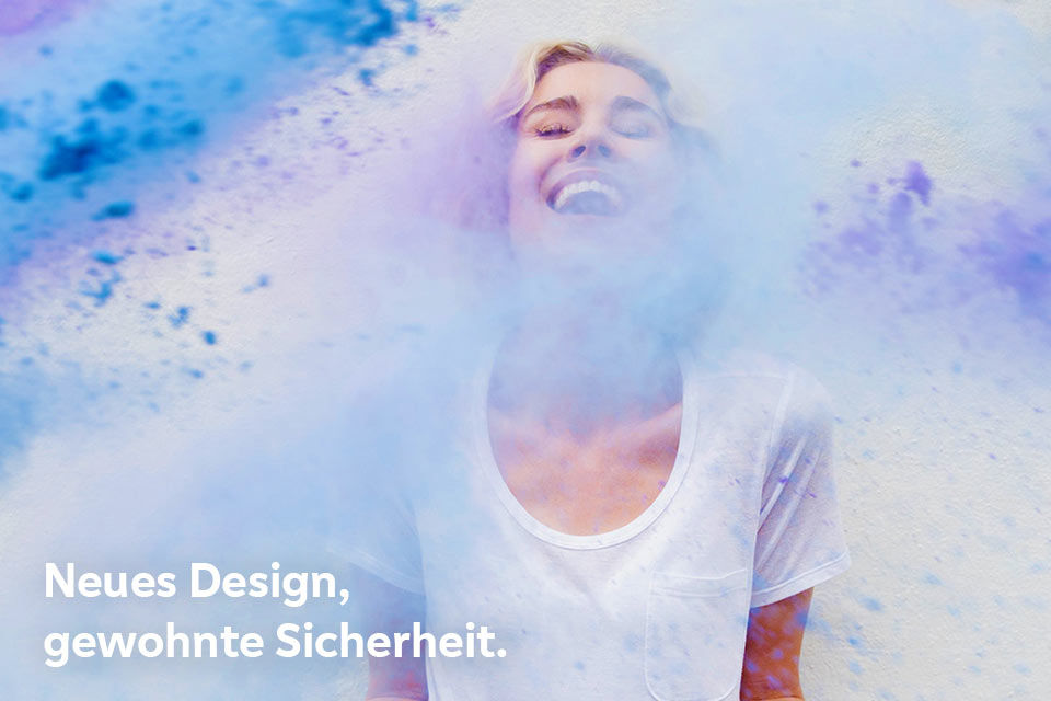 Eine junge Frau wird lachend mit Farbe beworfen
