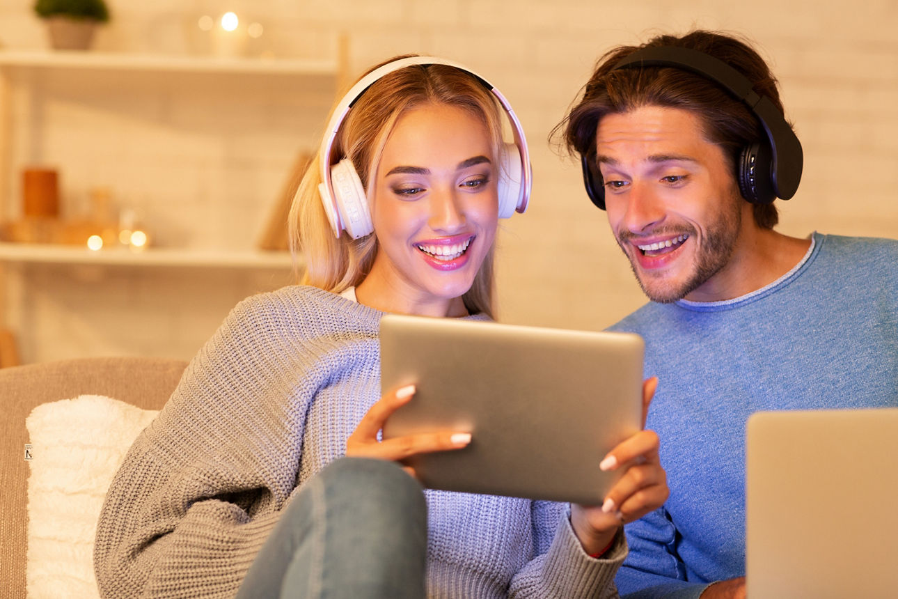 Frau hat Tablet-PC in der Hand, Mann schaut auf das Display