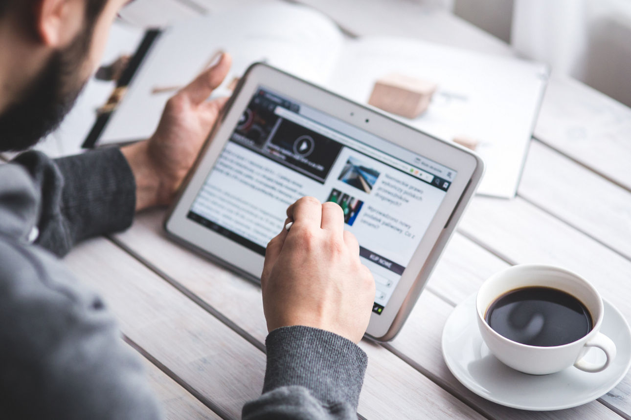 Mann schaut auf ein Tablet um aktuelle News zu lesen