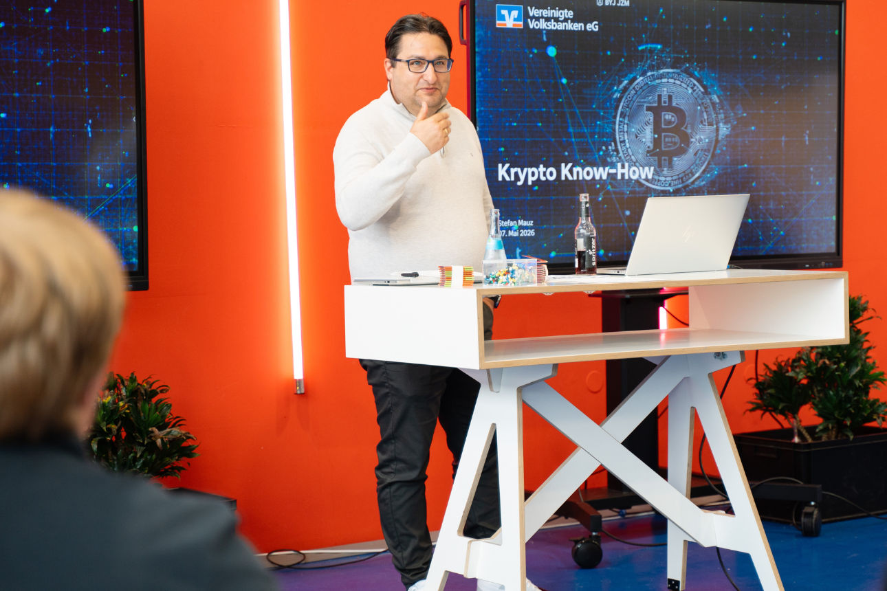 Vortrag zu Kryptowährungen vor Bildschirm mit „Krypto Know-How“ und Bitcoin-Grafik.