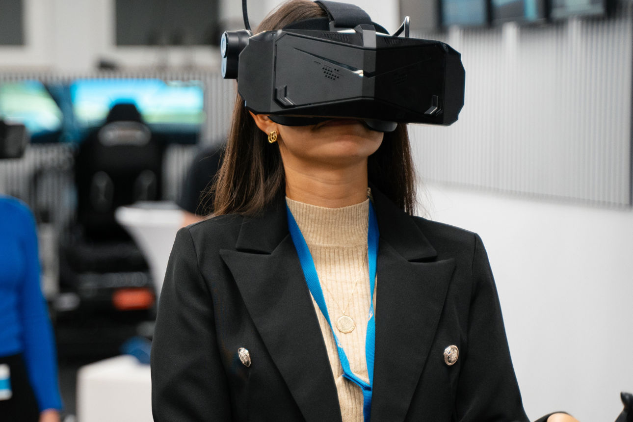 Personen testen Virtual-Reality-Brillen in moderner Umgebung mit digitaler Technik.
