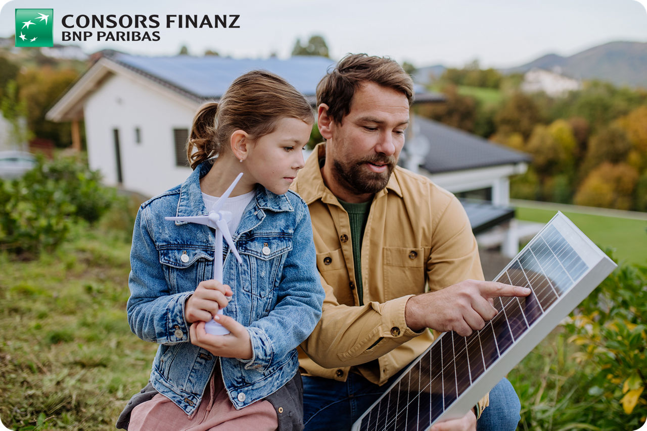 Vater und Tochter schauen gemeinsam auf ein Solarpanel