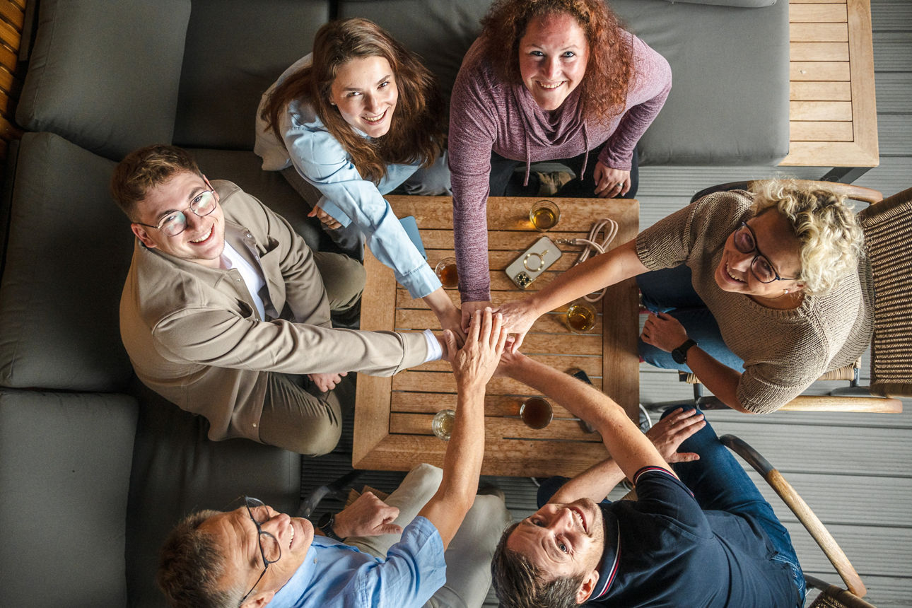 Lächelnde Menschen sitzen an ihrem Arbeitsplatz