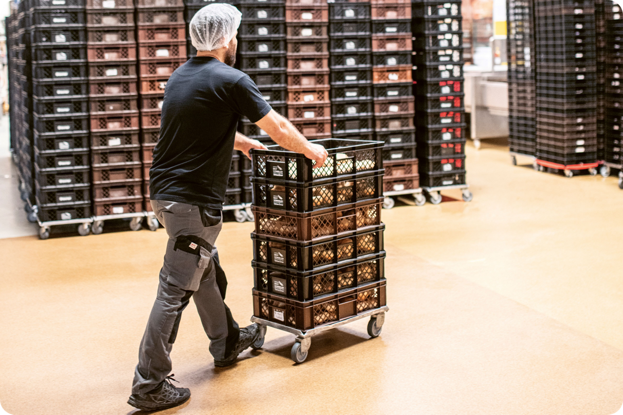 Ein Arbeiter schiebt Paletten durch eine Halle