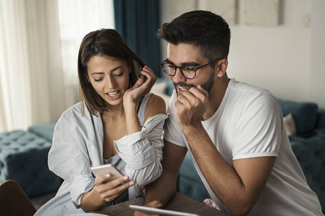 Ein junges Paar schaut gemeinsam auf ein Smartphone