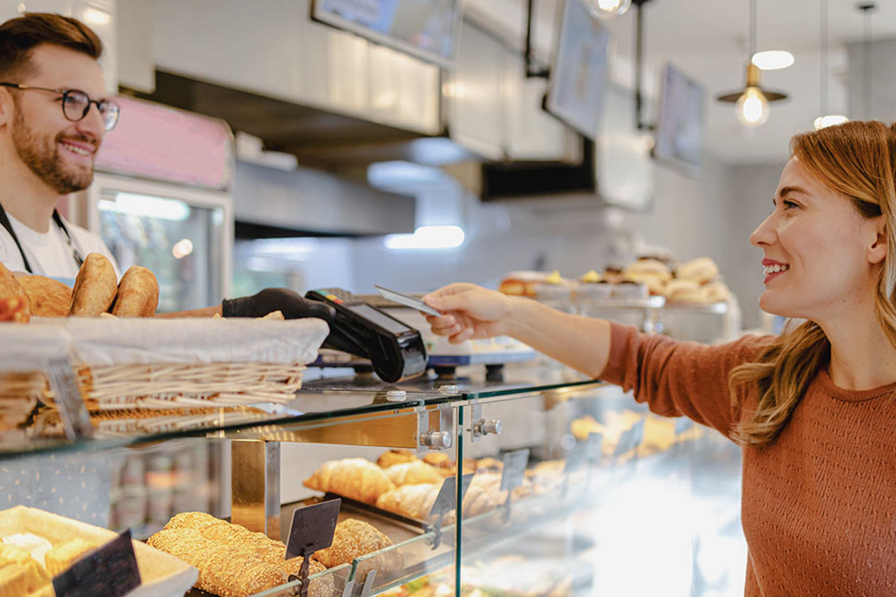 Frau bezahlt beim Bäcker mit ihrer girocard