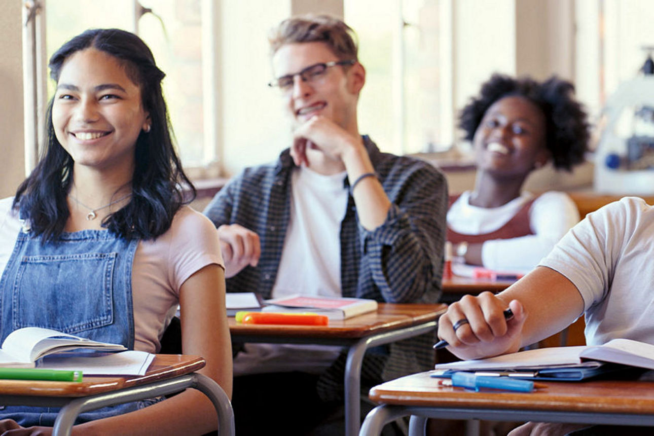 SchülerInnen sitzend lachend im Unterrichtsraum