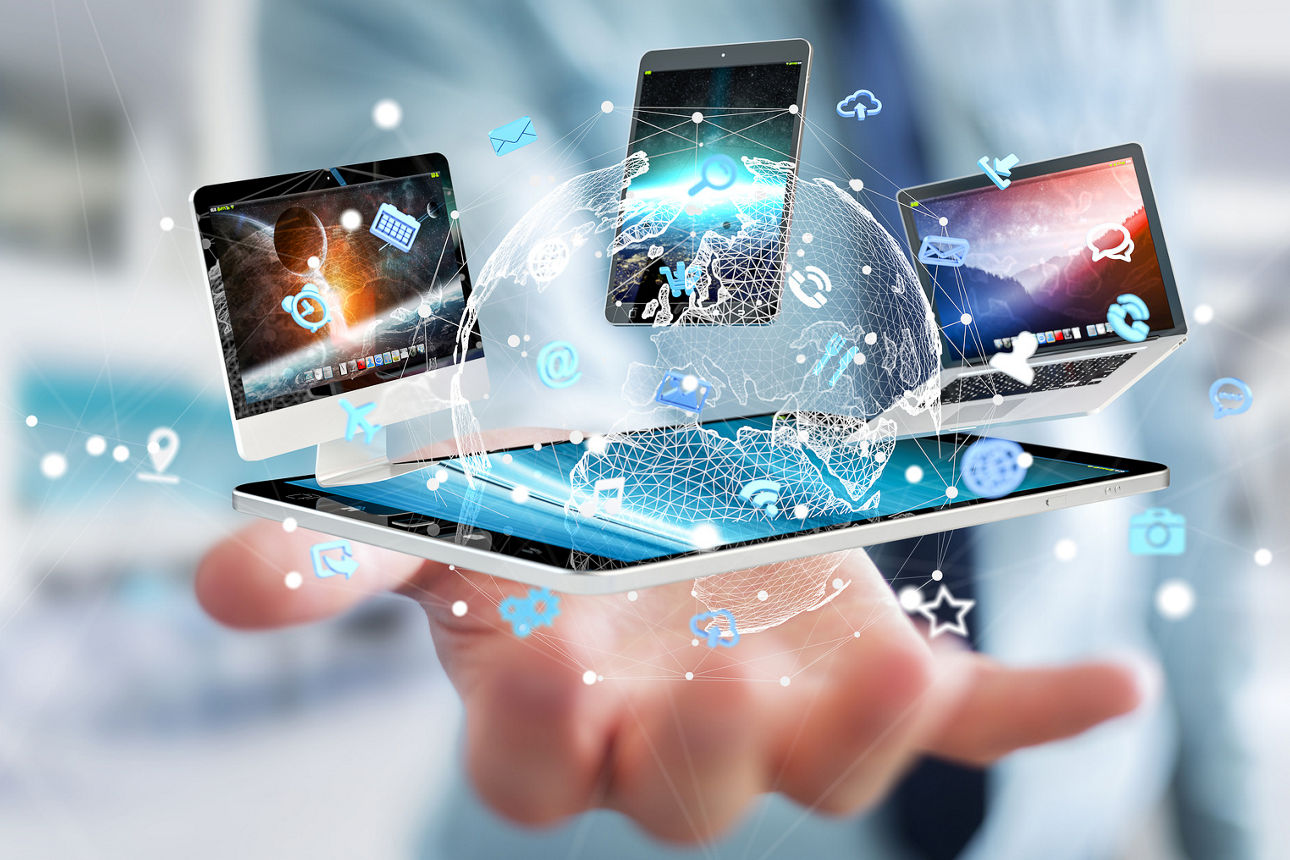 Über einer ausgestreckten Hand eines Mannes schweben Tablet, Handy, Laptop und Computer