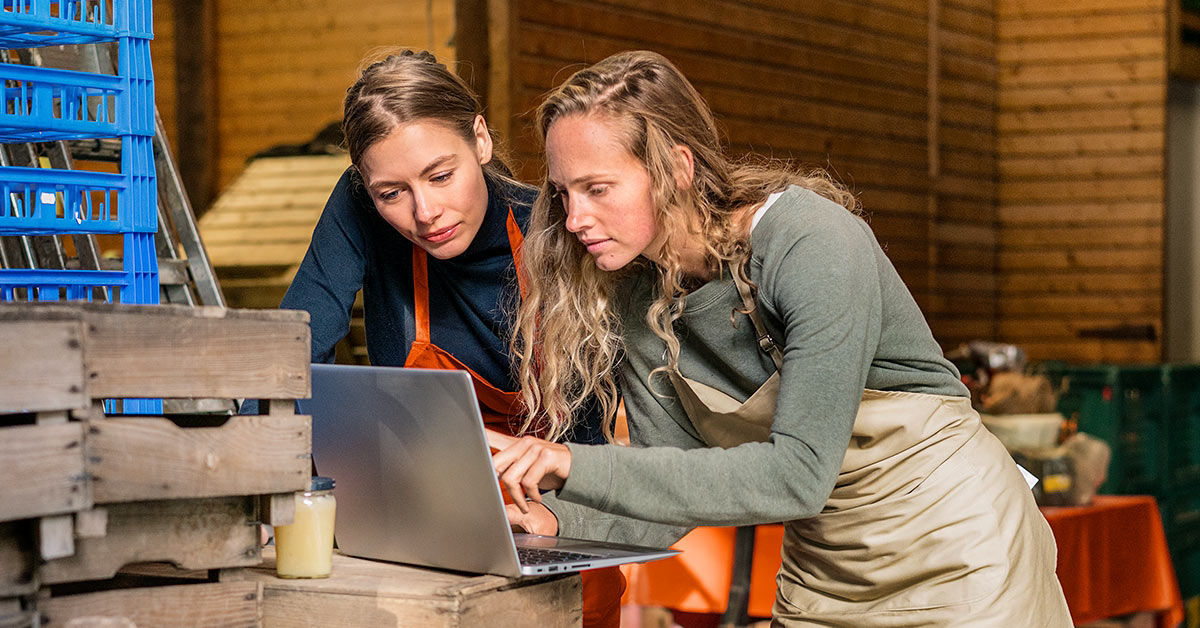 Zwei Frauen schauen gemeinsam auf einem Laptop