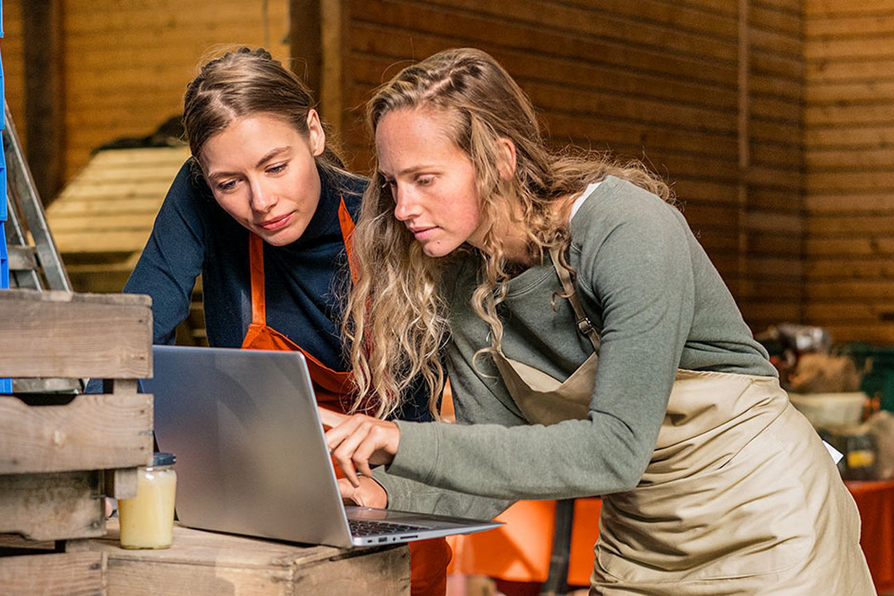 Zwei Frauen schauen gemeinsam auf einem Laptop
