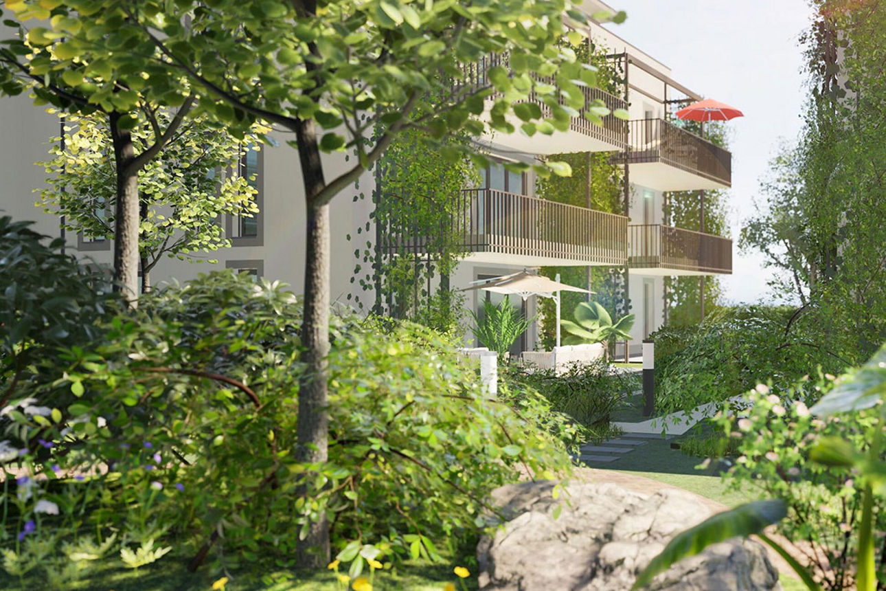 Moderne Wohnanlage mit hellen Fassaden und Balkonen, eingebettet in eine üppige, grüne Gartenlandschaft mit Bäumen und Sträuc