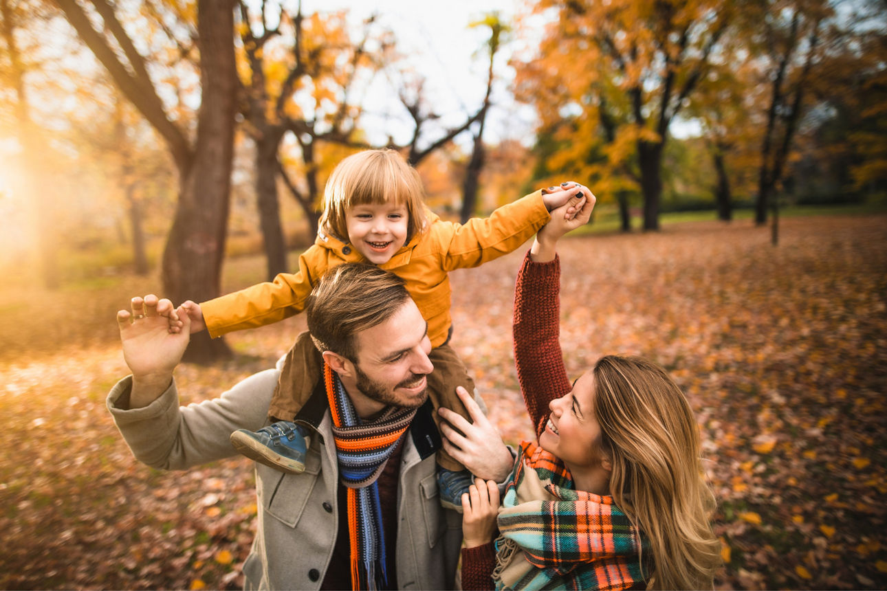 Familie mit Kleinkind bei einem Waldspaziergang im herbstlichen Wald