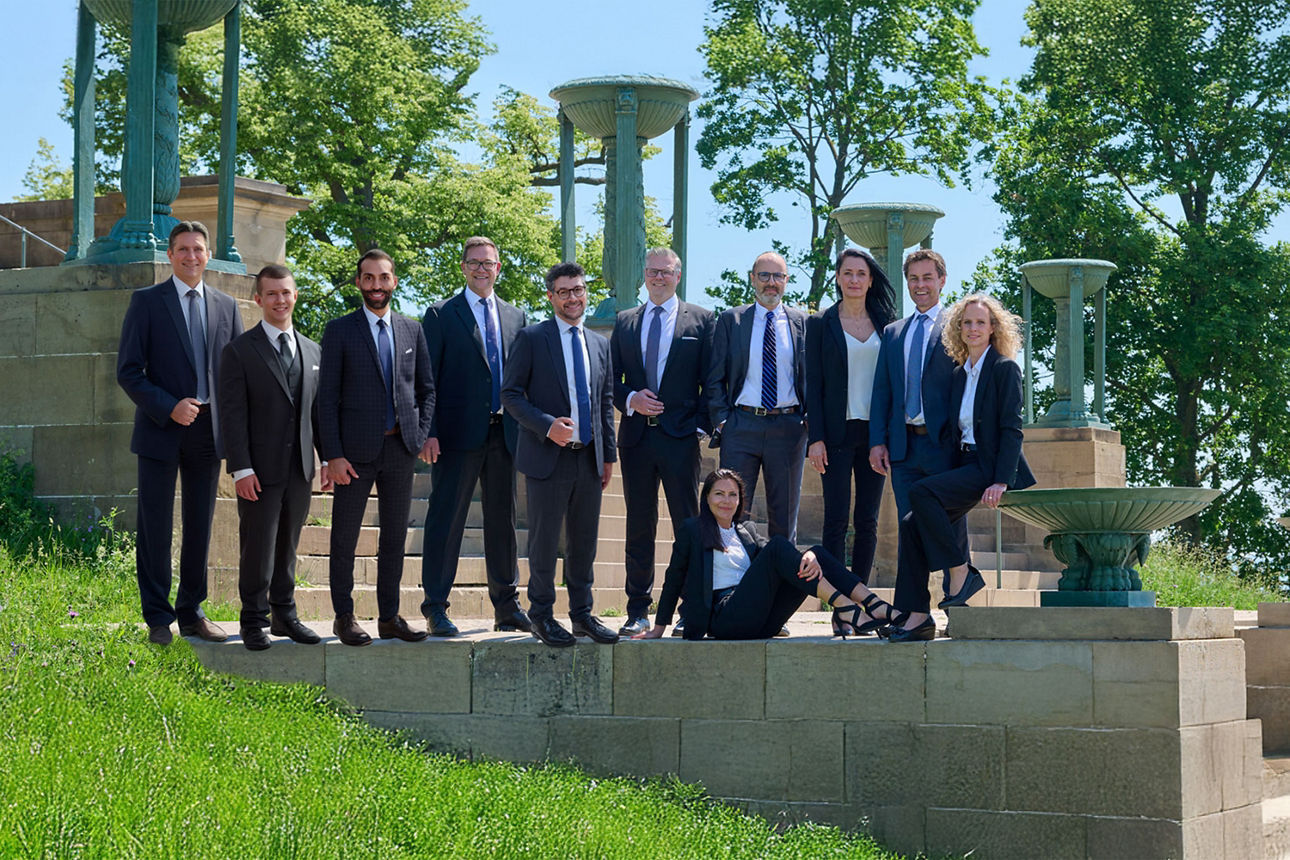 Viele Menschen in Anzügen stehen auf einer Mauer