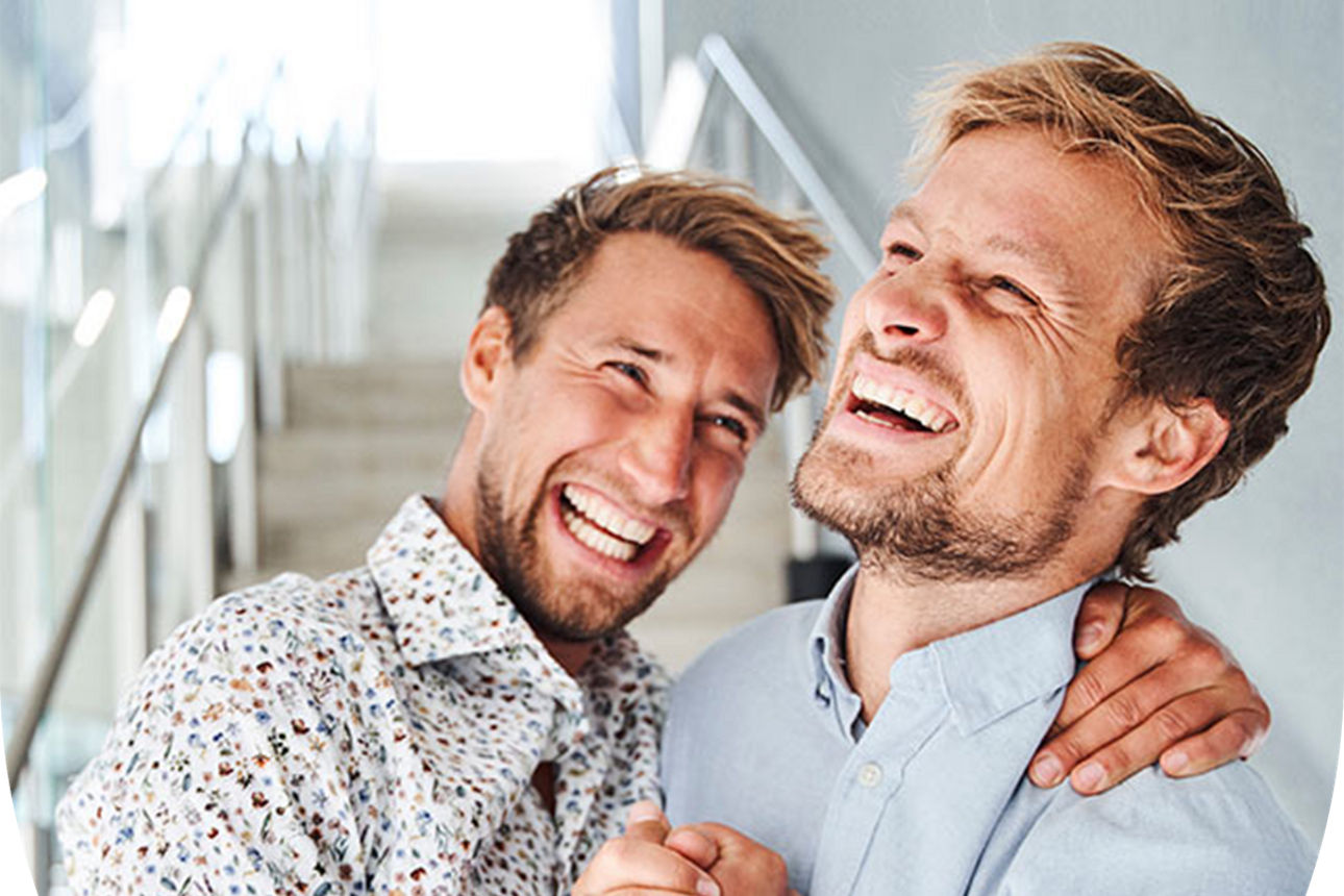 Zwei Männer, die sich lachend in den Armen liegen