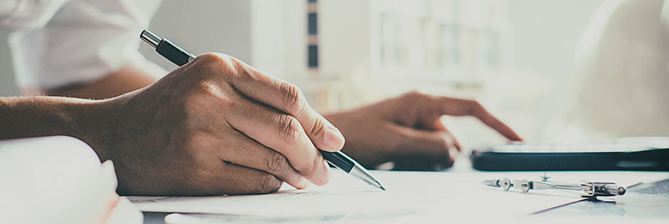 Die Hand einer Frau, die einen mechanischen Stift hält, während sie mit der anderen Hand auf einem Tablet tippt