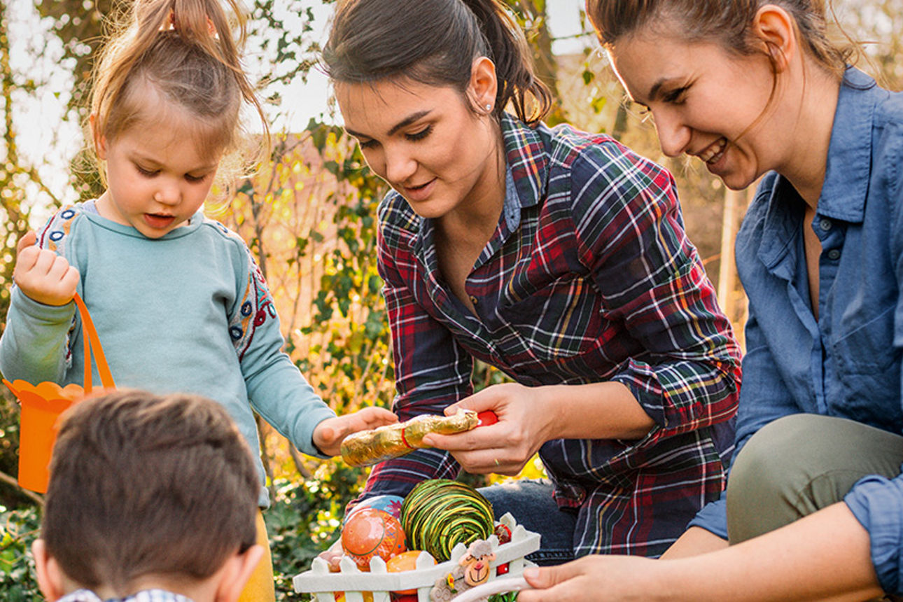 Zwei Frauen suchen mit Kinder Ostereier