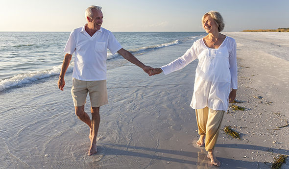 Mann und Frau Händchen halten am Strand