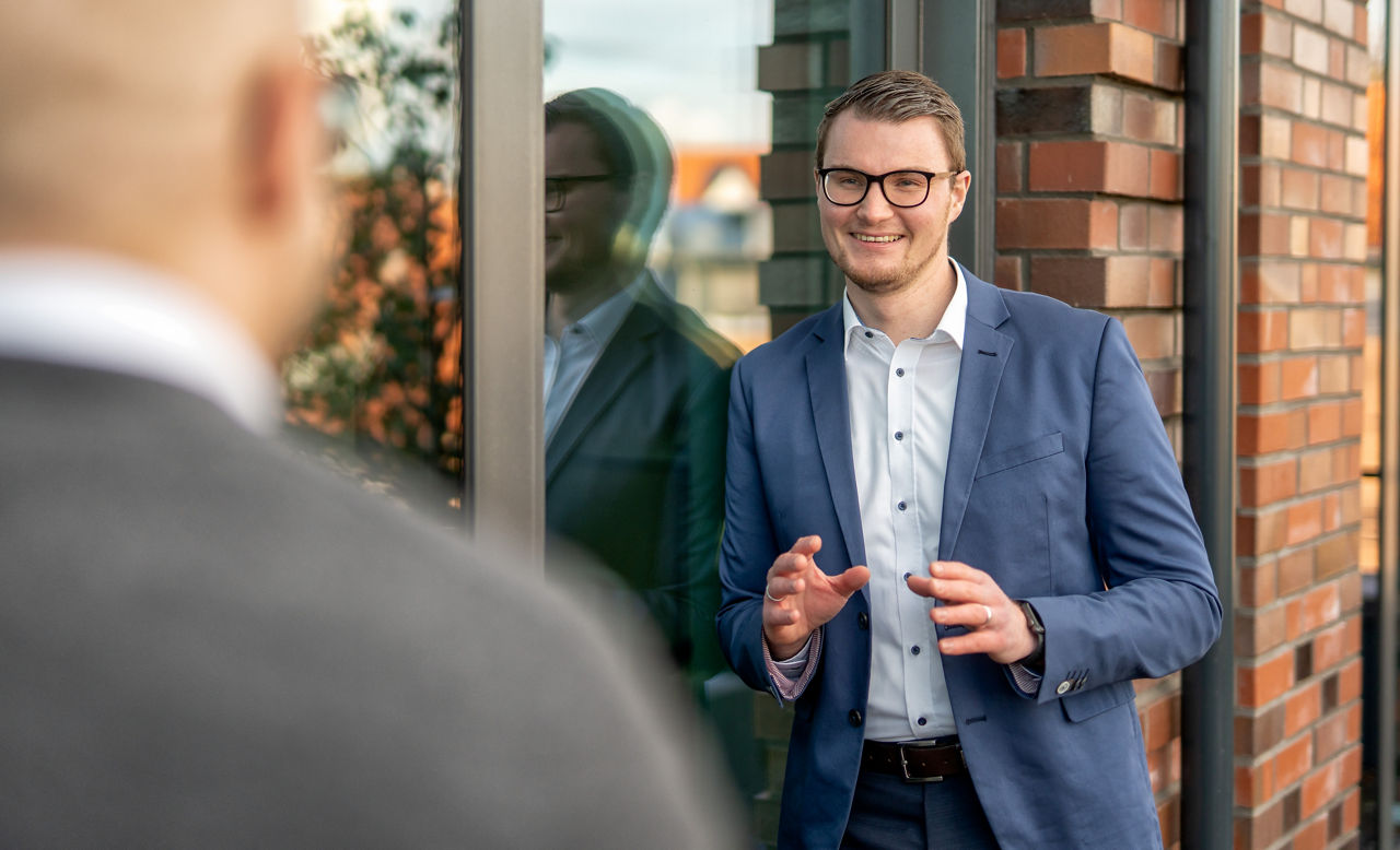 Firmenkundenbetreuer begrüßt lächelnd seinen Kunden