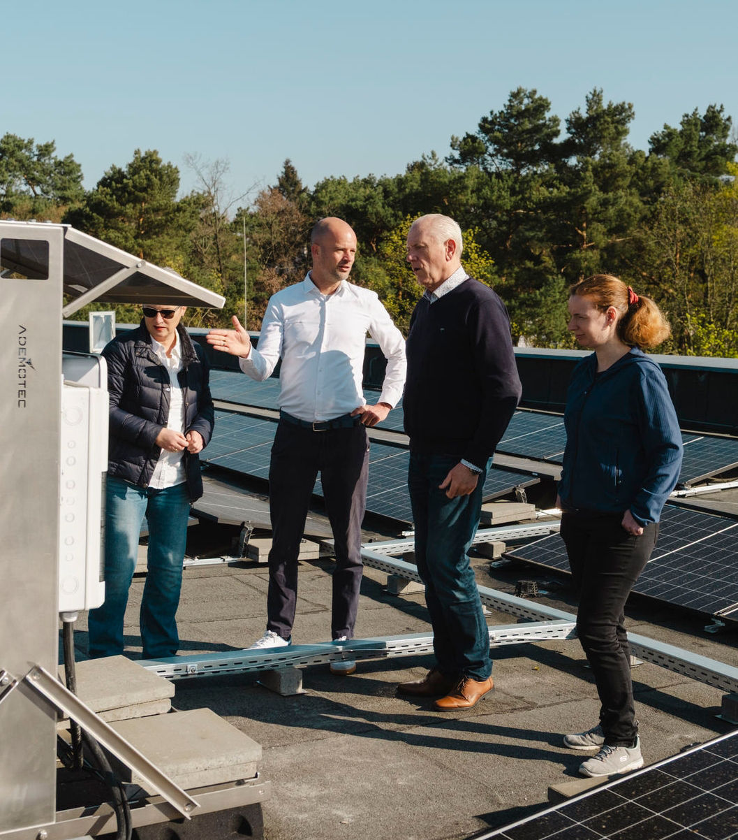 Gruppe von Menschen gestikuliert vor Photovoltaikanlagen 