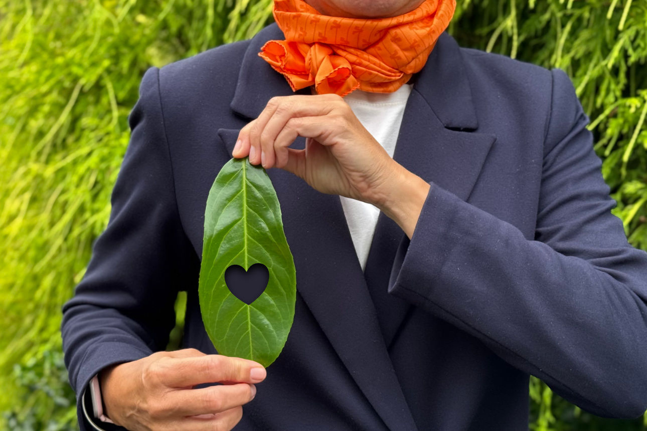 Eine Person hält ein Blatt mit einem Herzen in den Händen.