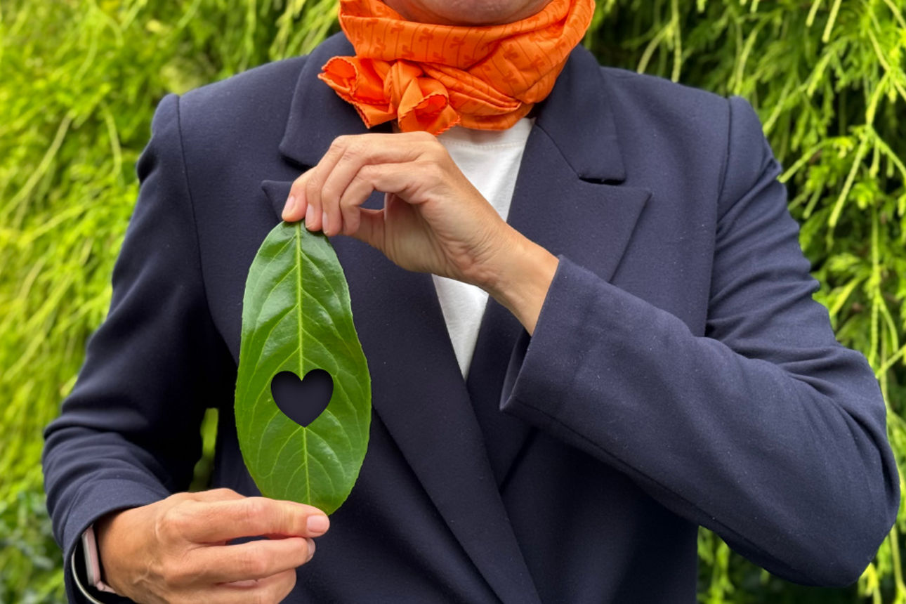 Eine Person hält ein Blatt mit einem Herzen in den Händen.