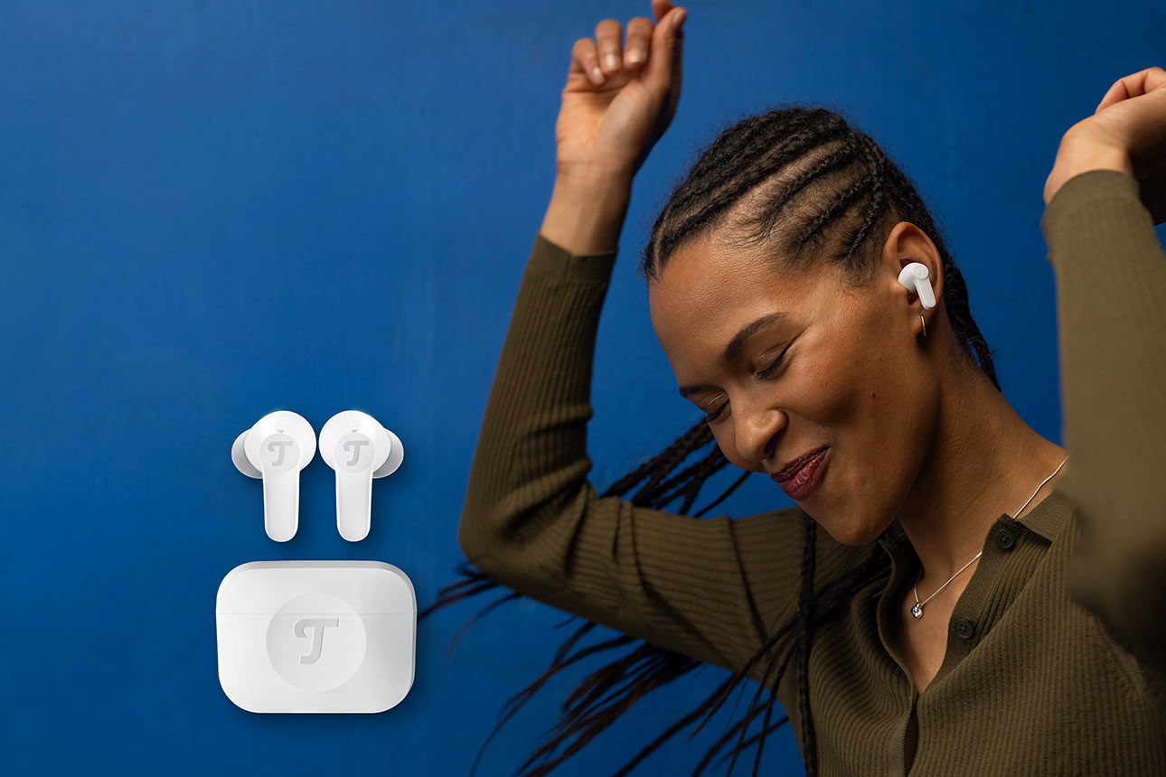 Frau mit Kopfhörern im Ohr tanzt, seitlich Kopfhörer mit Case abgebildet