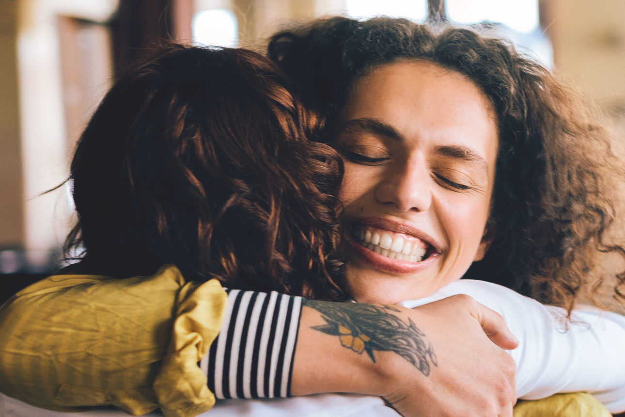 Zwei Personen umarmen sich erfreut