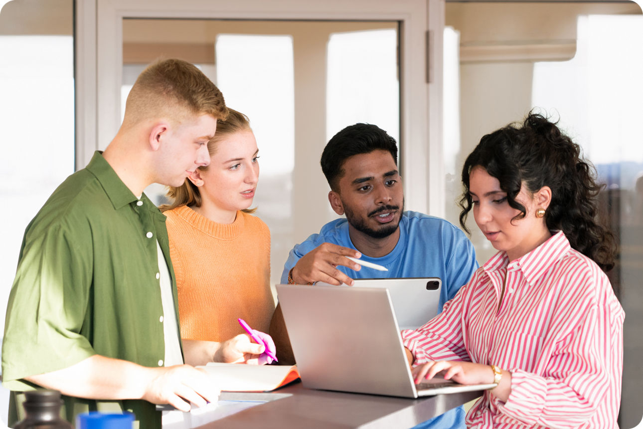 Eine Gruppe Jugendlicher steht um einen Laptop herum und diskutiert