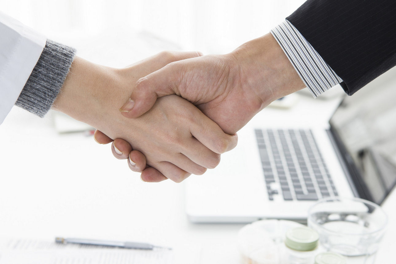 Arzt und Geschäftspartner geben sich die Hand