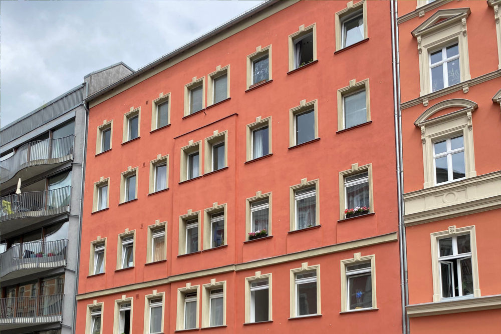 Außenansicht eines Mehrfamilienhauses mit roter Fassade