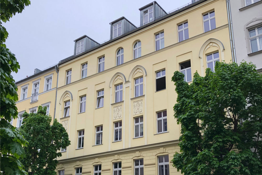 Außenansicht eines Mehrfamilienhauses mit hellgelber Fassade