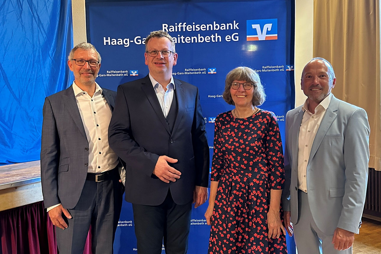 Drei Herren und eine Dame auf der Generalversammlung. 